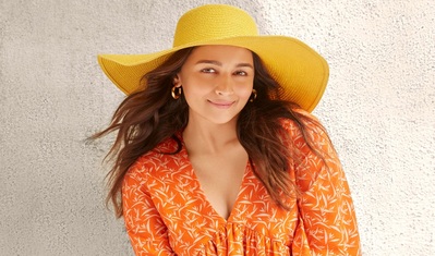 A smiling Alia Bhatt cradles her baby, Raha Kapoor, both wearing Ed-a-Mamma clothing with playful colour. #aliabhatt #rahakapoor #eda-a-mamma